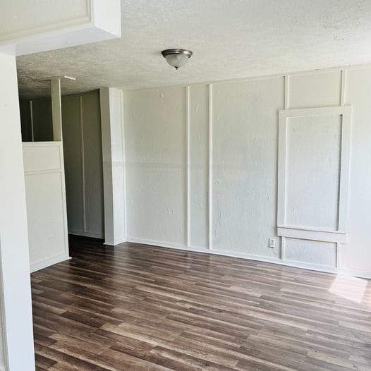 empty room featuring dark wood finished floors and a textured ceiling