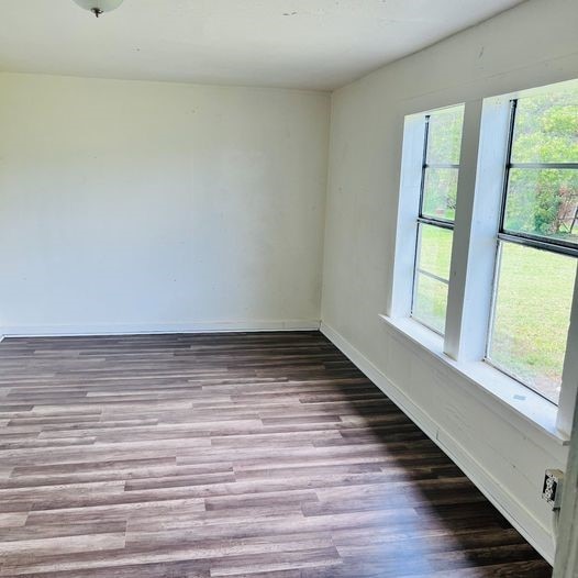 unfurnished room with light wood-style flooring and baseboards