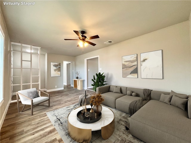 living area with a ceiling fan, baseboards, visible vents, and wood finished floors