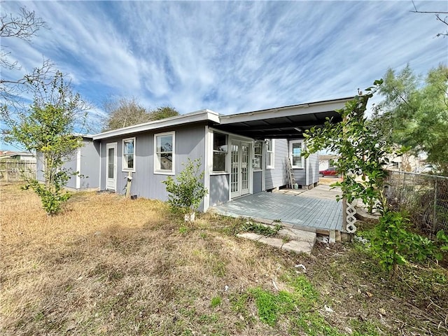 rear view of house featuring french doors and fence