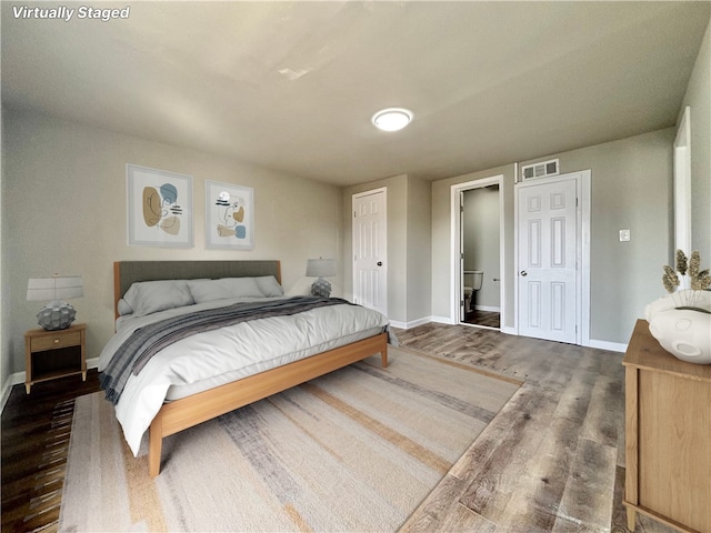 bedroom with visible vents, baseboards, and wood finished floors