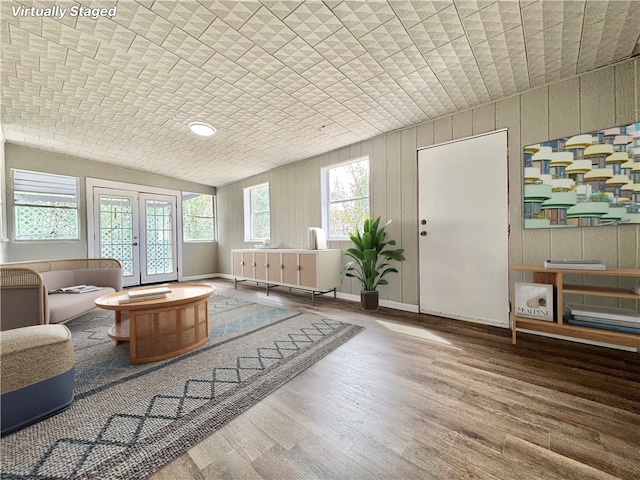 interior space with brick ceiling, baseboards, wood finished floors, and french doors