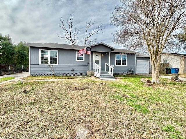 view of front of property featuring an attached garage, a front yard, and fence