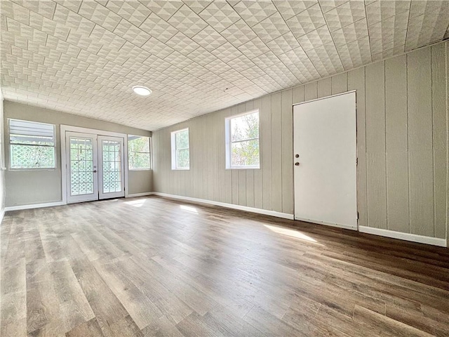 interior space with french doors, wood finished floors, and baseboards