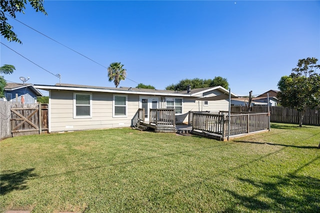 rear view of property featuring a yard and a deck