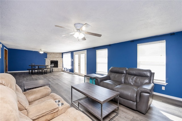 living room featuring hardwood / wood-style floors, ceiling fan, and a textured ceiling