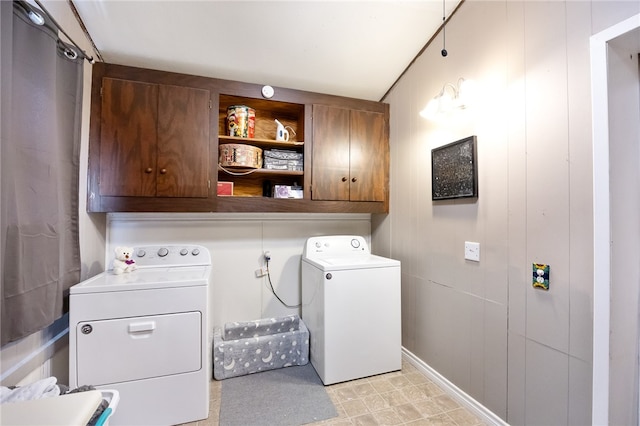 clothes washing area with cabinets and separate washer and dryer