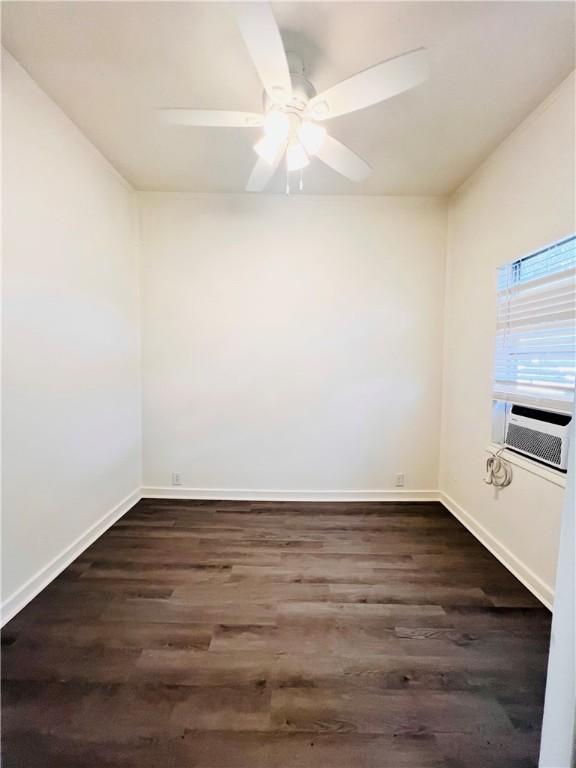 402 E Nopal St, Rockport, TX 78382 - unfurnished room featuring baseboards, cooling unit, a ceiling fan, and dark wood finished floors