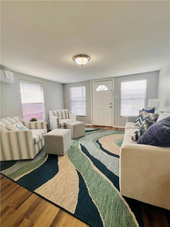 402 E Nopal St, Rockport, TX 78382 - living room with an AC wall unit, wood finished floors, and a wealth of natural light