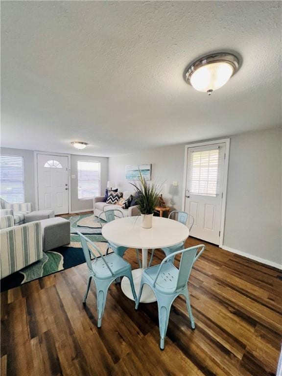 402 E Nopal St, Rockport, TX 78382 - dining space featuring baseboards, a textured ceiling, and wood finished floors