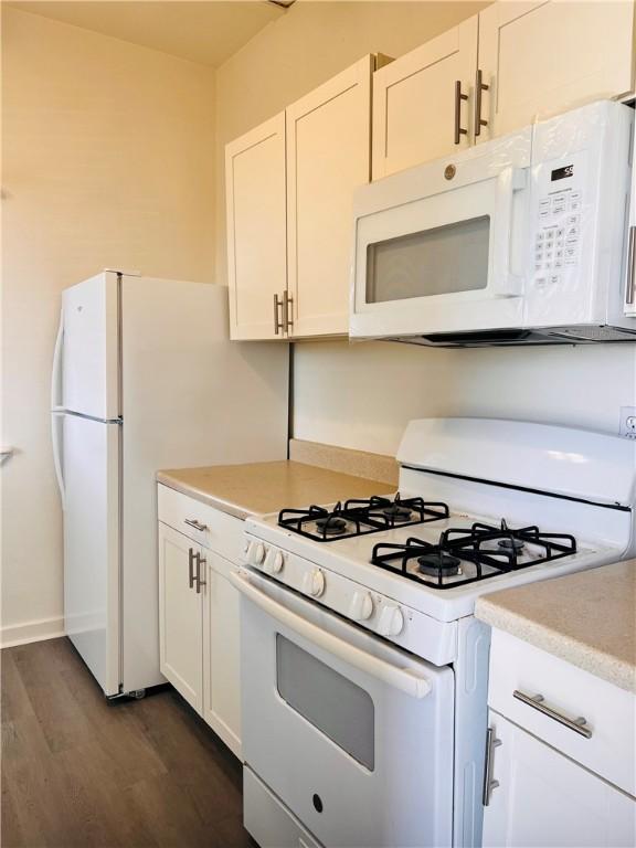 402 E Nopal St, Rockport, TX 78382 - kitchen featuring white appliances, light countertops, white cabinets, and dark wood-type flooring