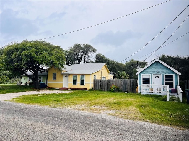 402 E Nopal St, Rockport, TX 78382 - bungalow with fence, a front lawn, and gravel driveway