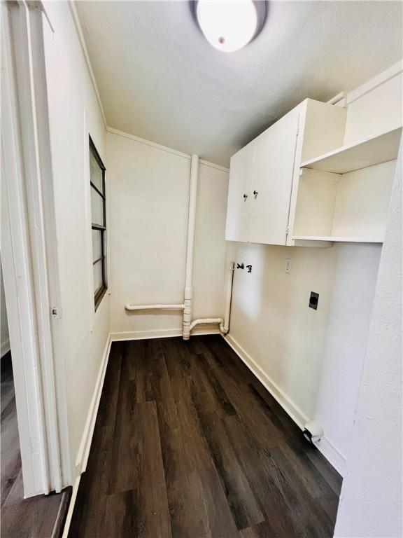 402 E Nopal St, Rockport, TX 78382 - washroom featuring cabinet space, baseboards, and dark wood-style floors