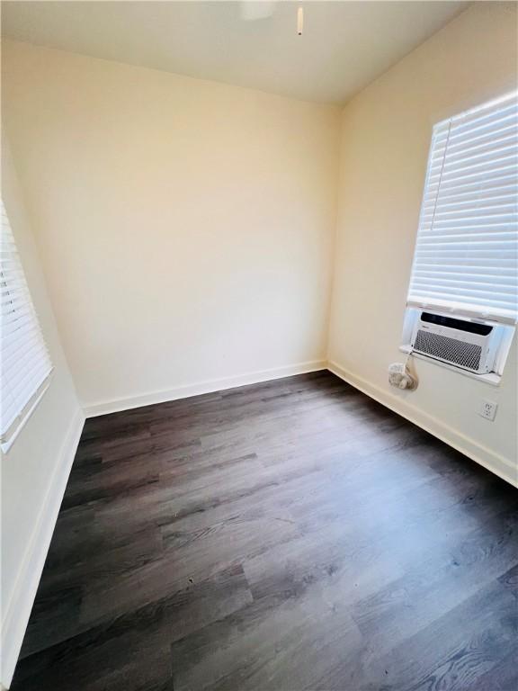 402 E Nopal St, Rockport, TX 78382 - spare room with baseboards, cooling unit, a ceiling fan, and dark wood-type flooring