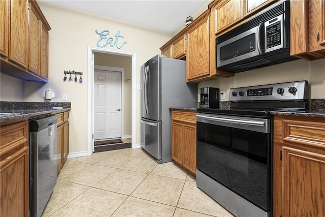 13706 Sea Horse Ave, Corpus Christi, TX 78418 - kitchen featuring stainless steel appliances, brown cabinets, light tile patterned flooring, and dark stone countertops