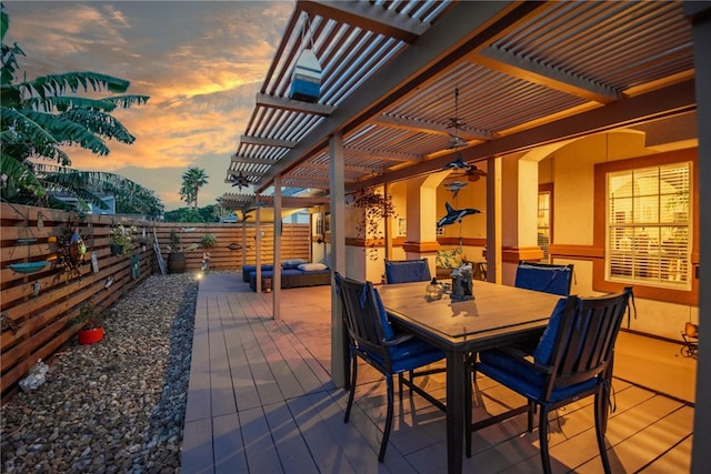 patio terrace at dusk with a pergola and ceiling fan