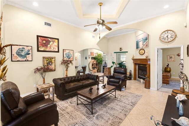 13706 Sea Horse Ave, Corpus Christi, TX 78418 - living room with arched walkways, a ceiling fan, light tile patterned floors, ornamental molding, and a fireplace