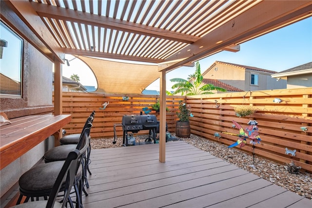 wooden deck featuring a grill and a pergola