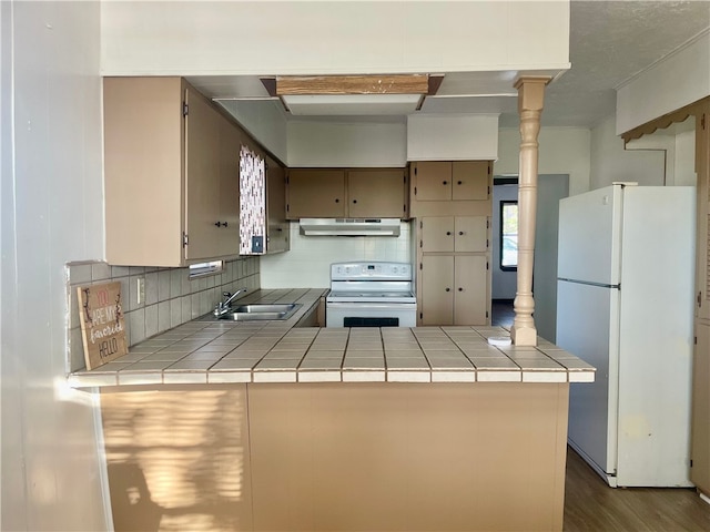 kitchen featuring kitchen peninsula, white appliances, tile counters, and sink