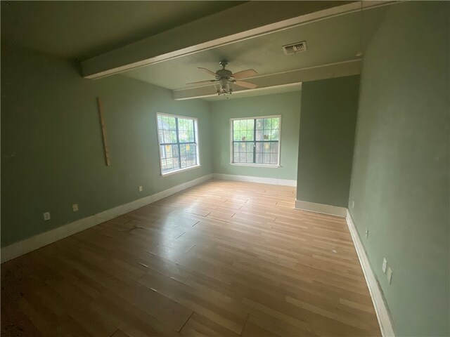 unfurnished room with beamed ceiling, ceiling fan, and light hardwood / wood-style floors