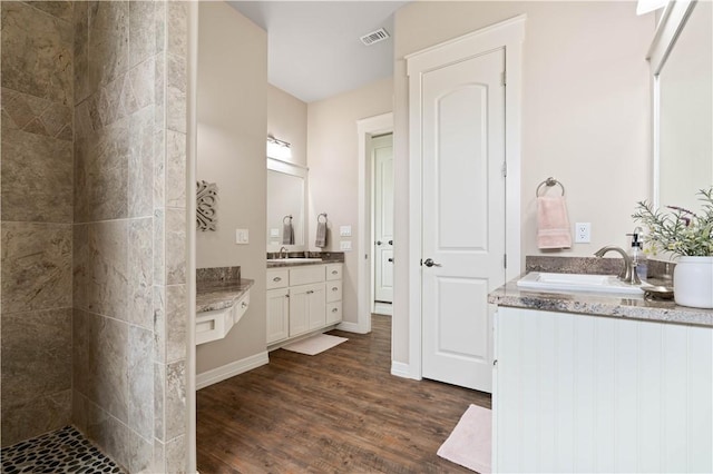 502 Sailhouse Way, Rockport, TX 78382 - full bathroom featuring two vanities, wood finished floors, a sink, and a tile shower