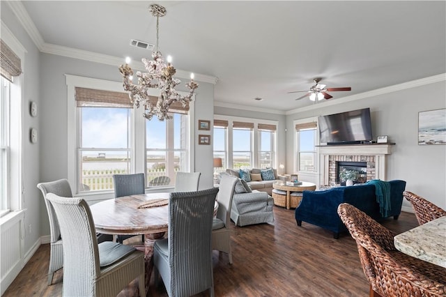 502 Sailhouse Way, Rockport, TX 78382 - dining space featuring ceiling fan with notable chandelier, a wealth of natural light, ornamental molding, and dark wood-style flooring