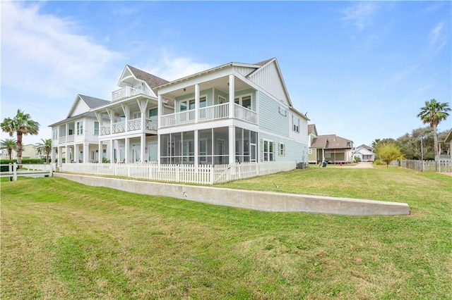 502 Sailhouse Way, Rockport, TX 78382 - back of house with board and batten siding, a lawn, fence, and a balcony