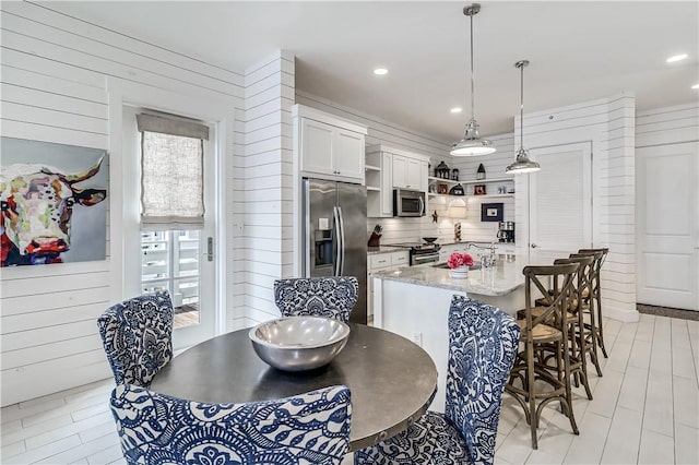 dining space with recessed lighting and wood walls