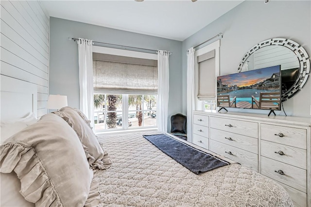 carpeted bedroom featuring wood walls