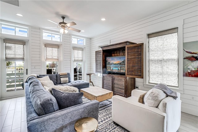 living room featuring ceiling fan, wood walls, visible vents, and recessed lighting