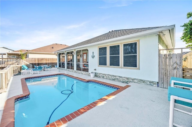 view of swimming pool featuring a patio area, a fenced backyard, a fenced in pool, and a sunroom