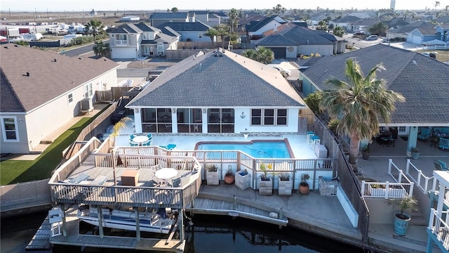 rear view of property with a fenced backyard, a residential view, a community pool, and a patio