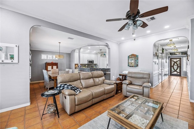 living area with ornamental molding, arched walkways, visible vents, and light tile patterned floors