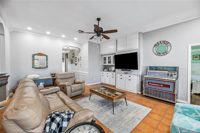 living area featuring ornamental molding, arched walkways, recessed lighting, and light tile patterned floors