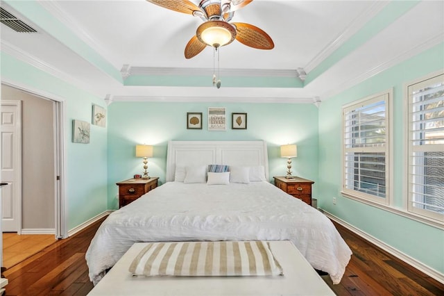 bedroom featuring visible vents, a tray ceiling, and hardwood / wood-style floors