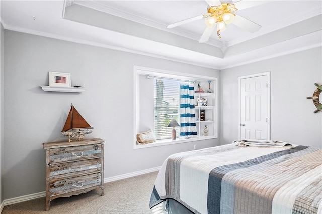 carpeted bedroom with baseboards, ornamental molding, a raised ceiling, and a ceiling fan