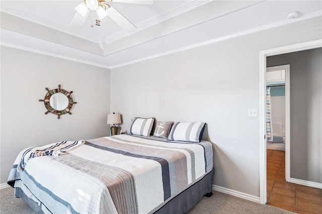 bedroom with baseboards, tile patterned floors, carpet, a tray ceiling, and crown molding