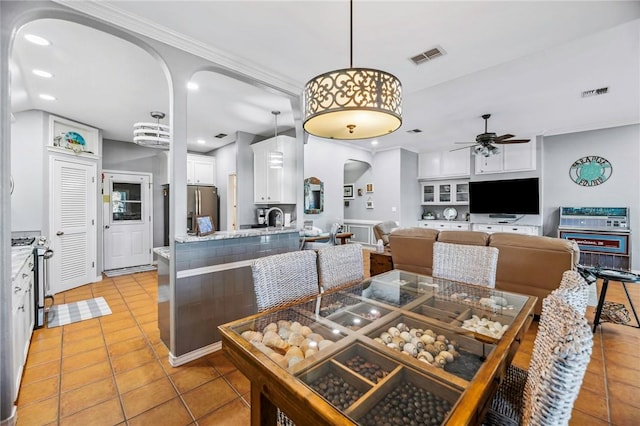 dining area with arched walkways, ceiling fan, visible vents, and recessed lighting