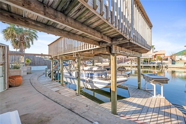 dock area with a water view and boat lift