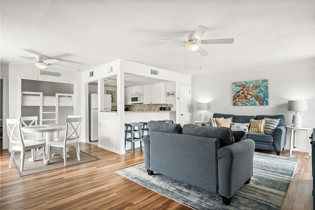 living room featuring ceiling fan and light hardwood / wood-style flooring