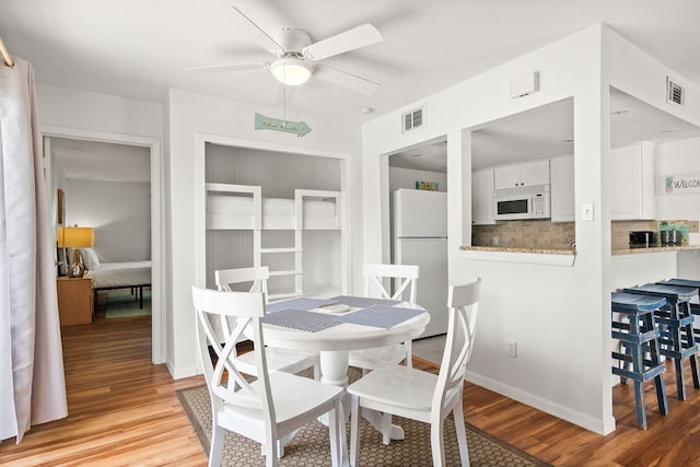 dining space featuring light hardwood / wood-style floors and ceiling fan