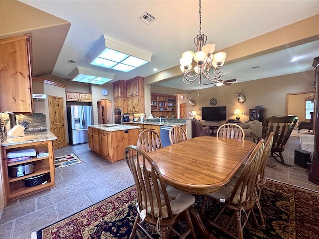 7605 Bayonne Dr, Corpus Christi, TX 78414 - dining space with stone tile floors, a chandelier, and a ceiling fan