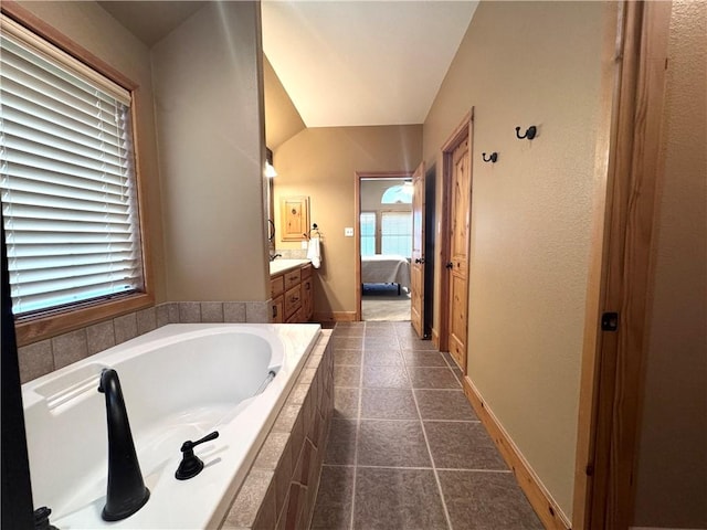 7605 Bayonne Dr, Corpus Christi, TX 78414 - full bathroom with vanity, a garden tub, ensuite bathroom, vaulted ceiling, and tile patterned floors
