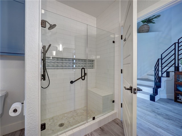 bathroom with hardwood / wood-style floors and a shower with door