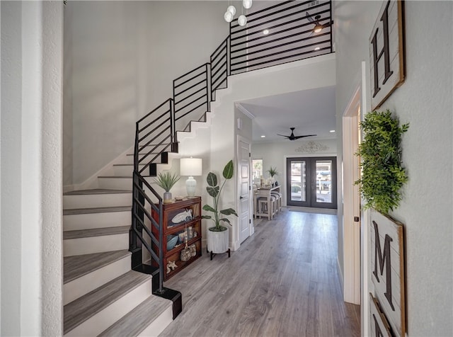 entrance foyer featuring french doors, ceiling fan, hardwood / wood-style floors, and a high ceiling