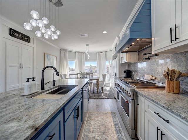 kitchen featuring white cabinetry, ornamental molding, double oven range, light stone countertops, and decorative backsplash