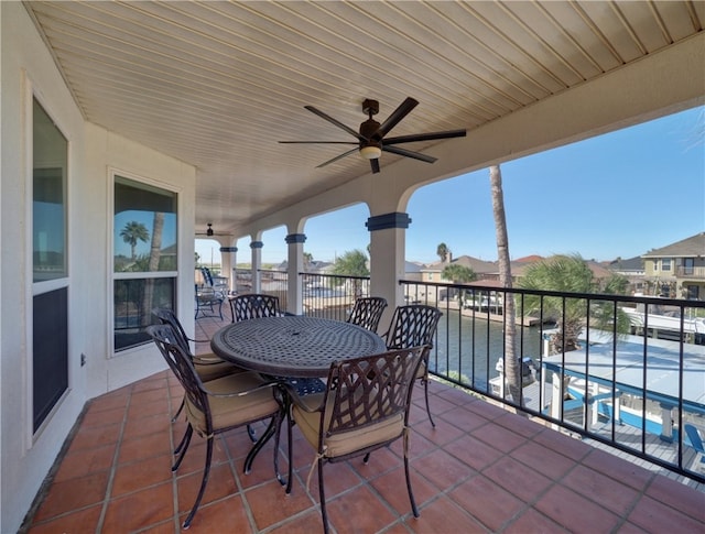 view of patio / terrace featuring a balcony, ceiling fan, and a water view