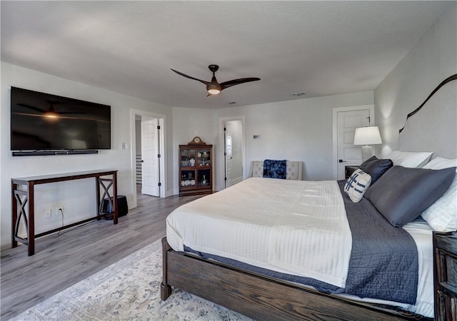 bedroom featuring a textured ceiling, ceiling fan, and light wood-type flooring