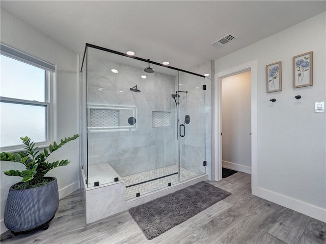 bathroom with an enclosed shower and wood-type flooring