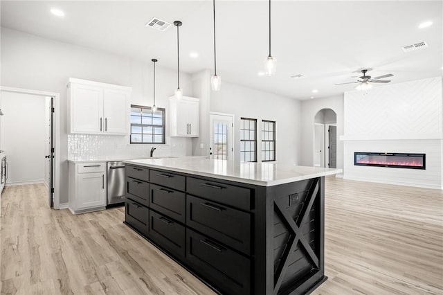 kitchen featuring visible vents, tasteful backsplash, light wood-type flooring, and white cabinetry